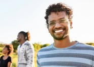 Guy in front of diverse group of friends wearing glasses